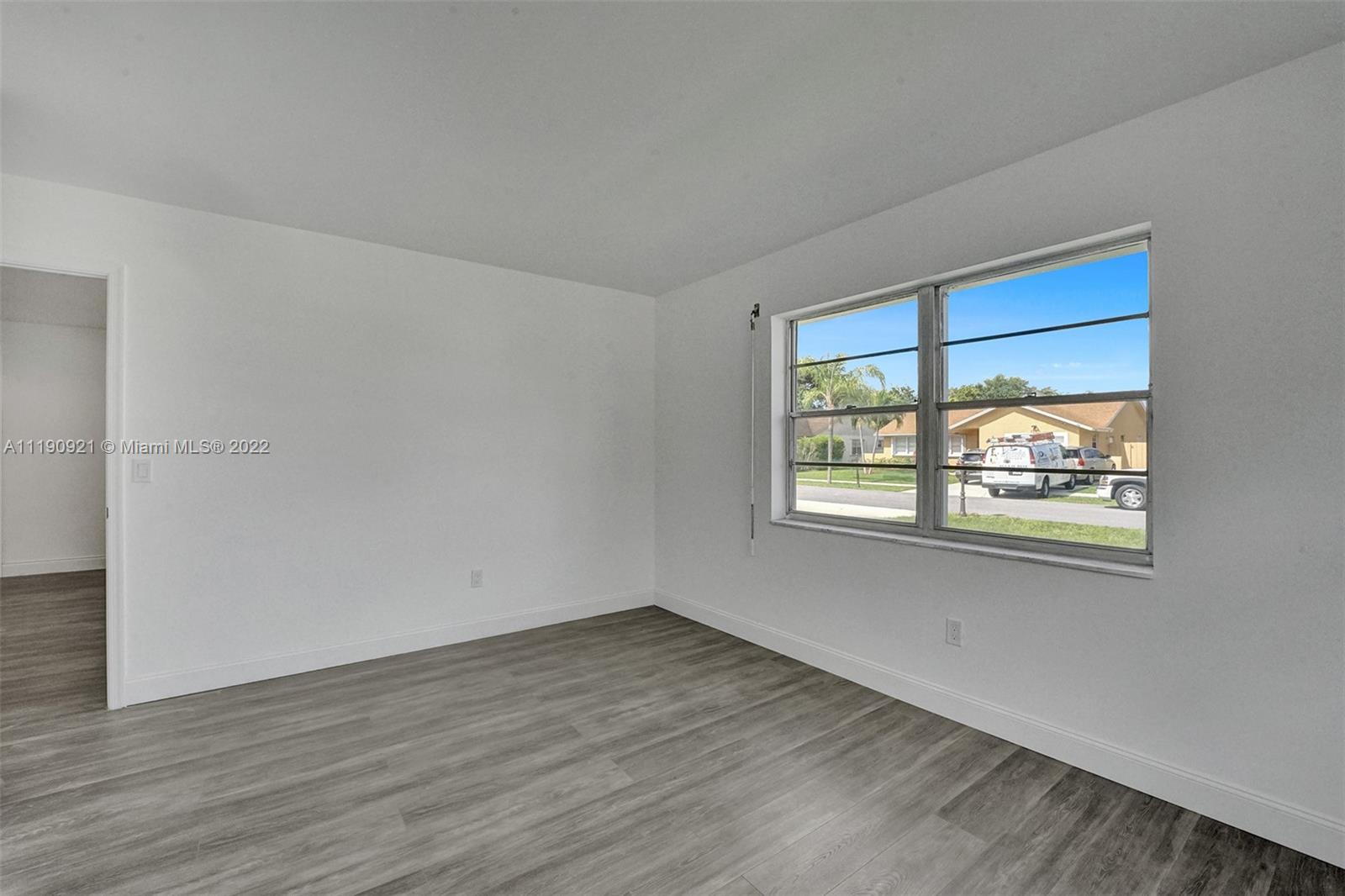 23098 Southwest 55th Avenue Boca Raton, FL 33433 - Photo 22 of 49 a view of an empty room with wooden floor and a window