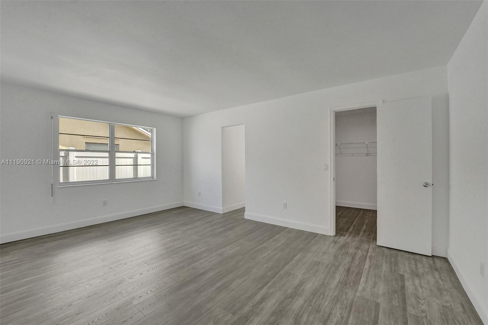 23098 Southwest 55th Avenue Boca Raton, FL 33433 - Photo 26 of 49 an empty room with wooden floor and windows