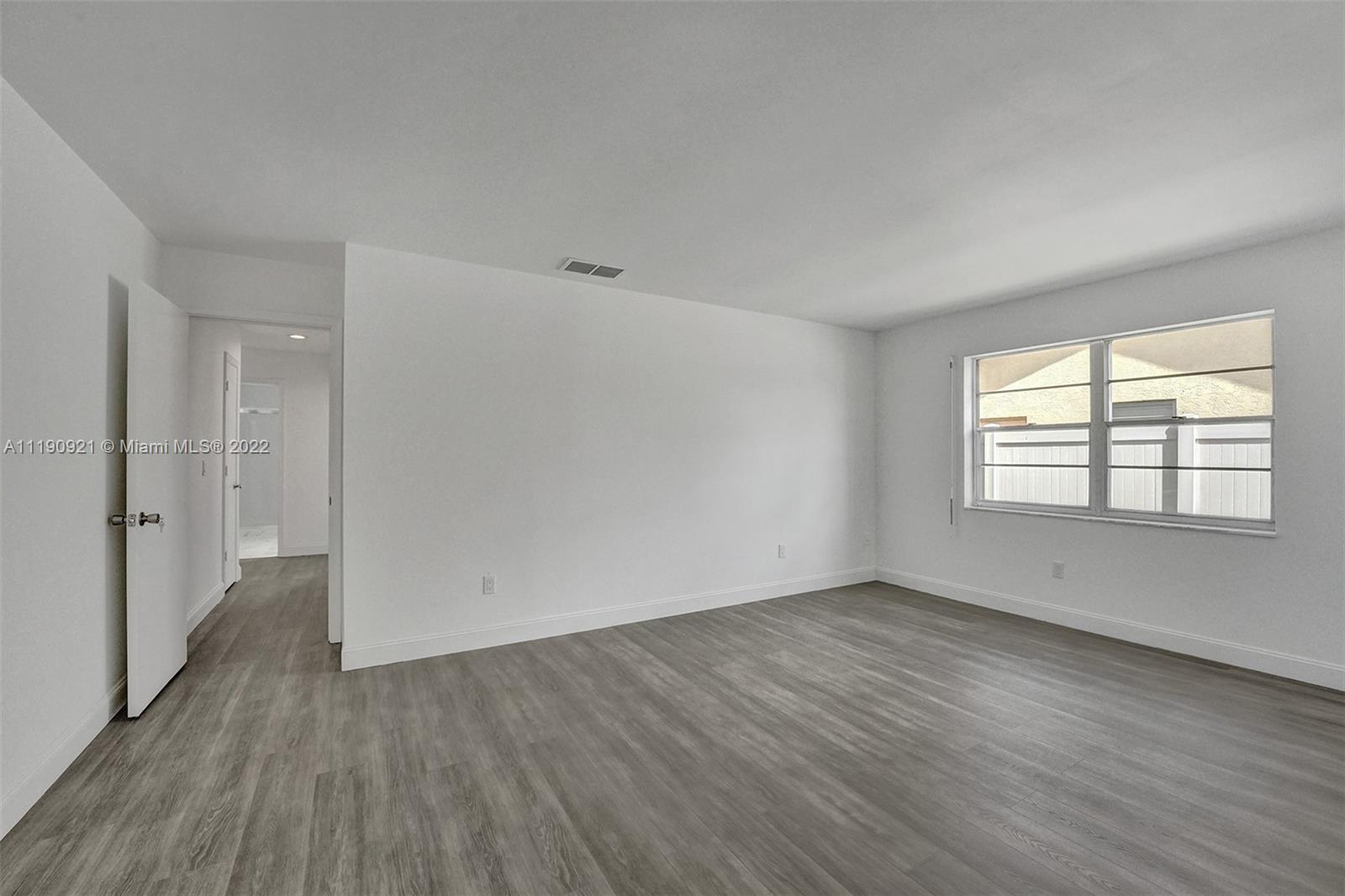 23098 Southwest 55th Avenue Boca Raton, FL 33433 - Photo 28 of 49 a view of an empty room with wooden floor and a window