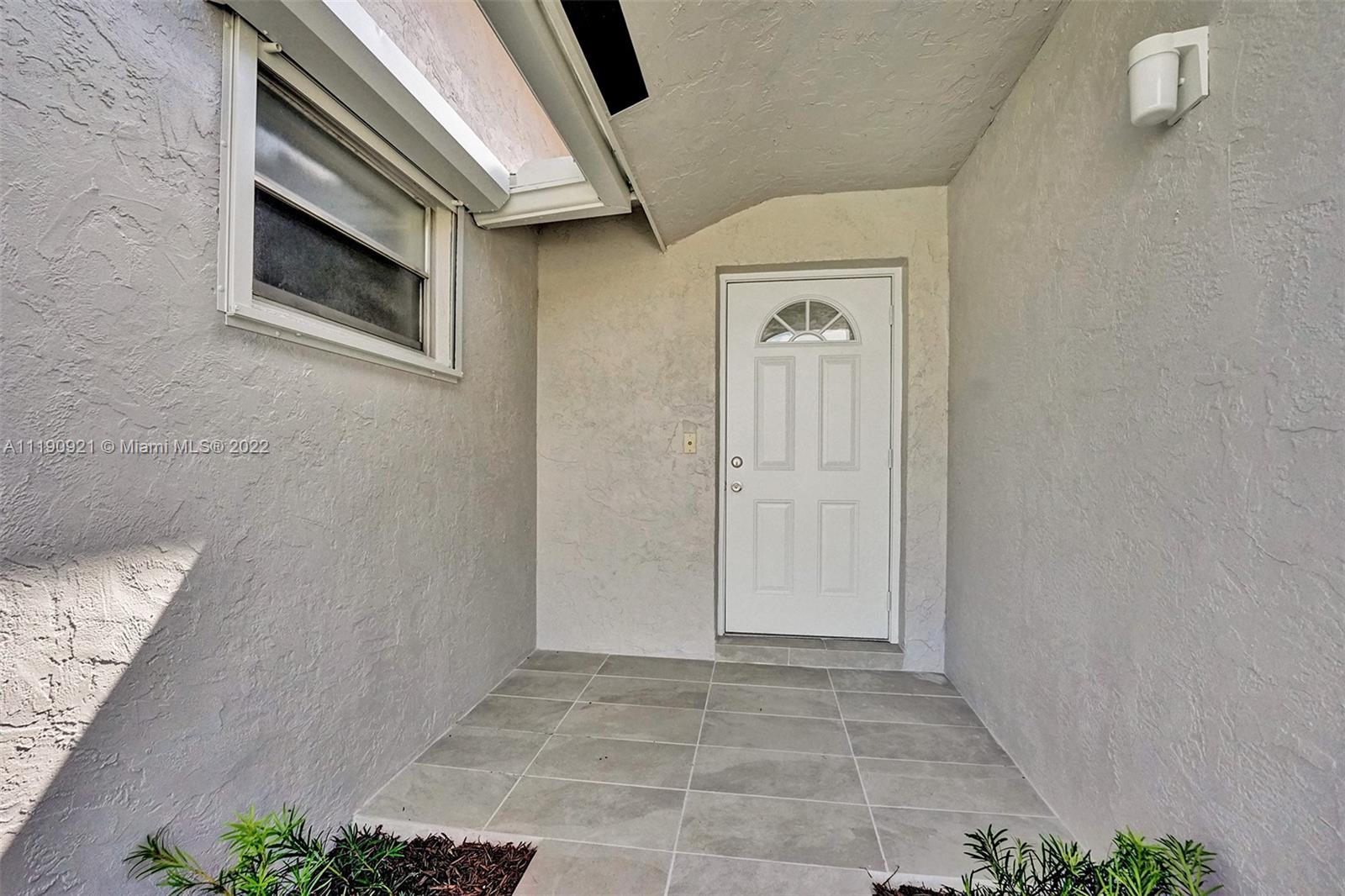 23098 Southwest 55th Avenue Boca Raton, FL 33433 - Photo 3 of 49 a view of a hallway with wooden floor and a potted plant