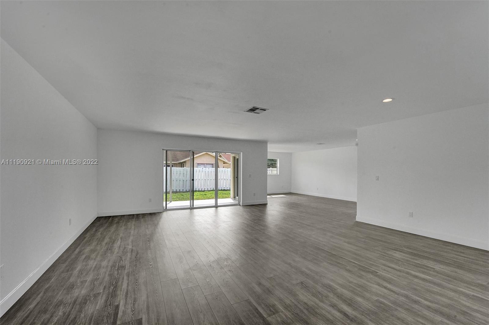 23098 Southwest 55th Avenue Boca Raton, FL 33433 - Photo 6 of 49 a view of an empty room with wooden floor and window