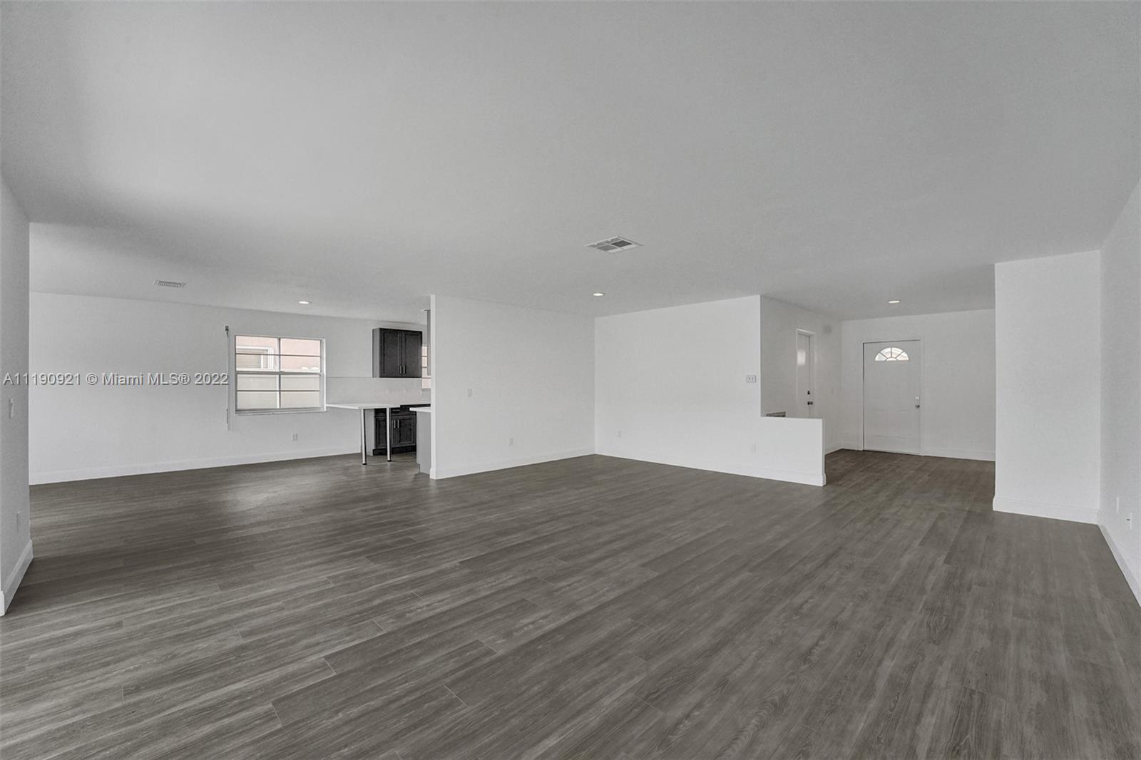 23098 Southwest 55th Avenue Boca Raton, FL 33433 - Photo 7 of 49 a view of empty room with wooden floor and window