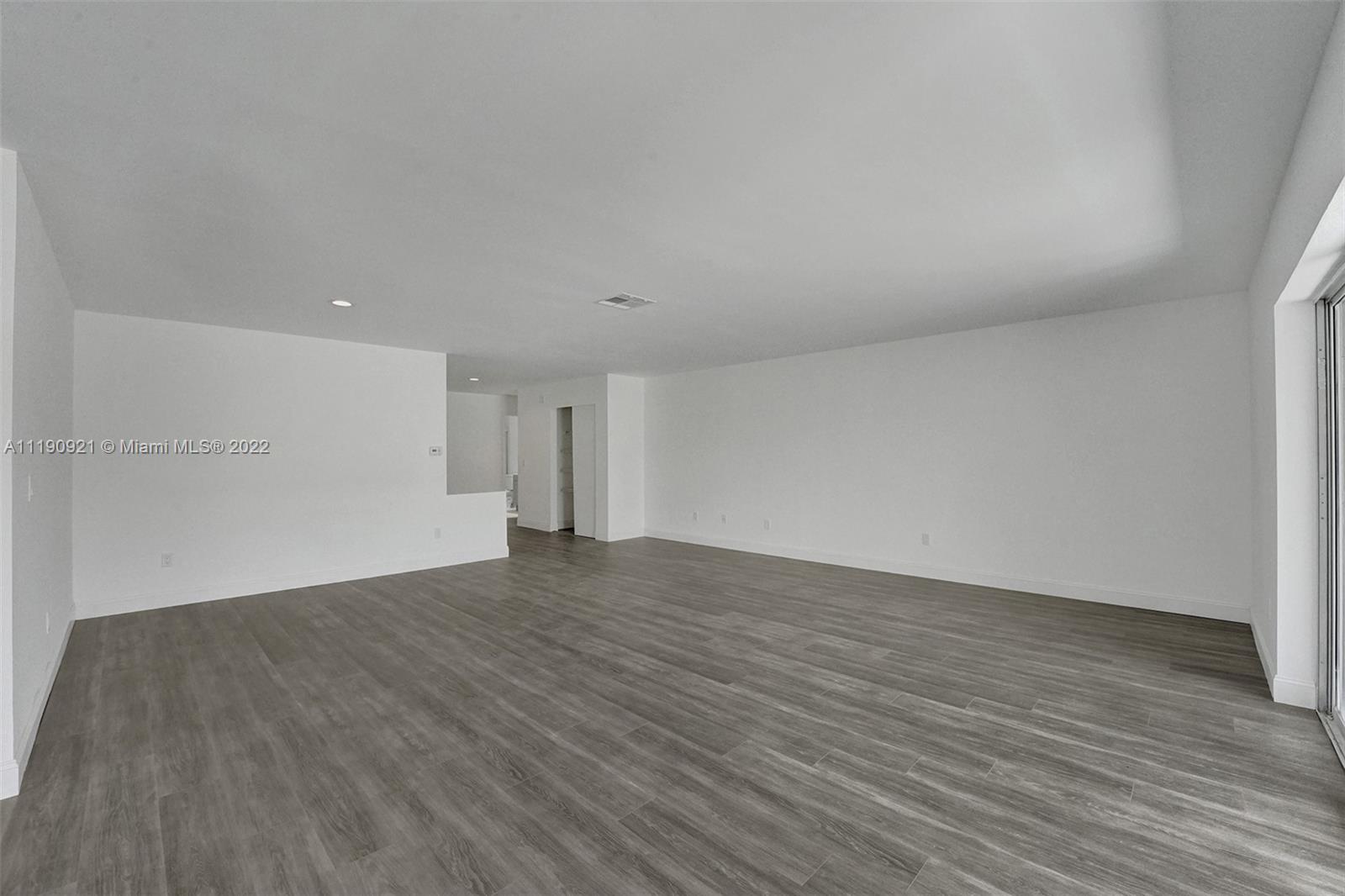 23098 Southwest 55th Avenue Boca Raton, FL 33433 - Photo 8 of 49 a view of an empty room with wooden floor and a window