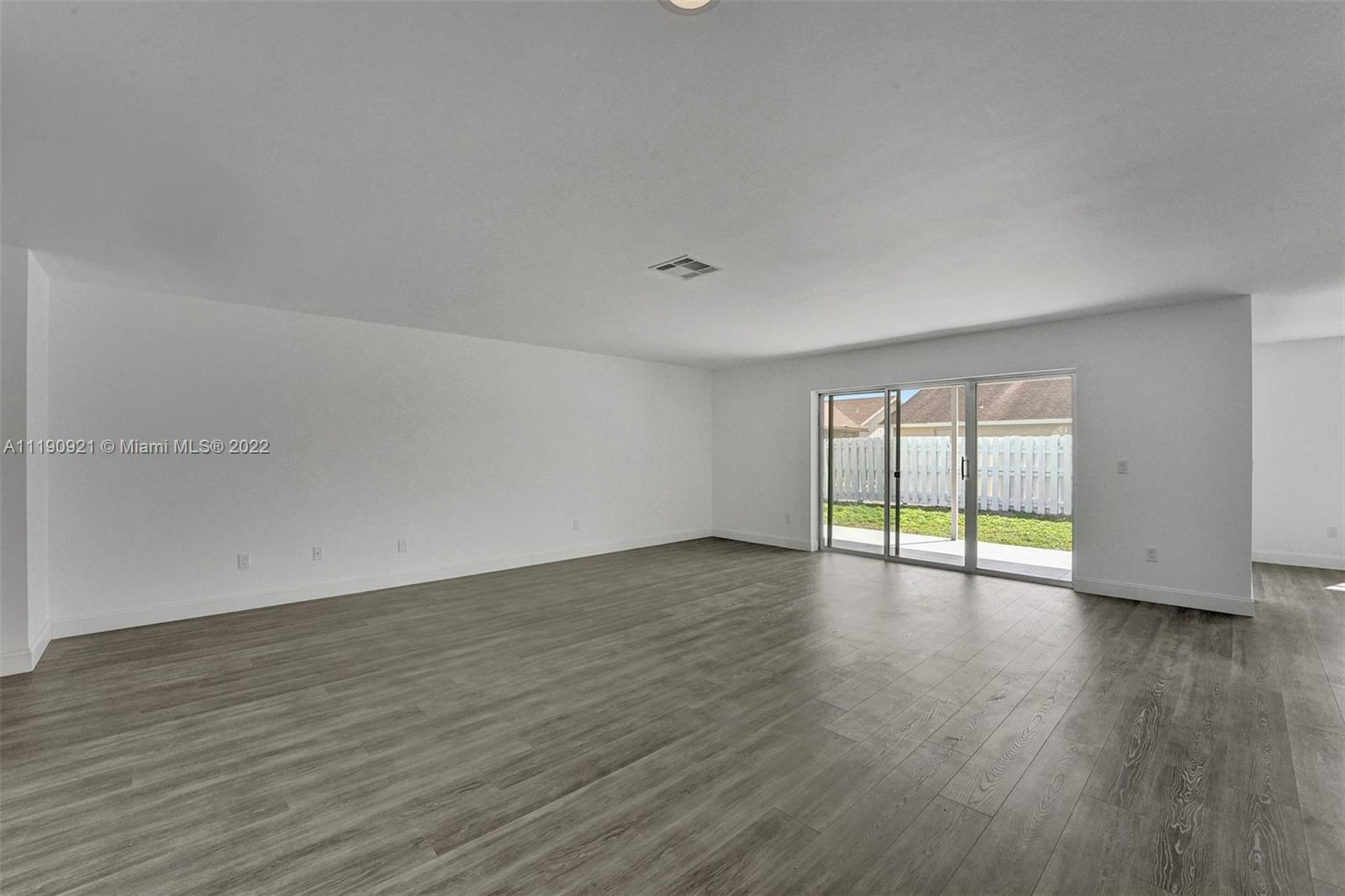 23098 Southwest 55th Avenue Boca Raton, FL 33433 - Photo 9 of 49 a view of an empty room with wooden floor and a window