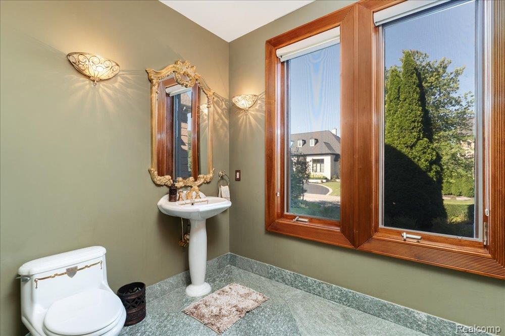 3543 Cedar Brook Drive Rochester, MI 48309 - Photo 37 of 99 Pedestal sink with an ornate gold-framed mirror, flanked by decorative wall sconces
