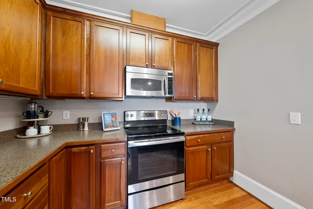 a kitchen with granite countertop wooden cabinets stainless steel appliances and a sink