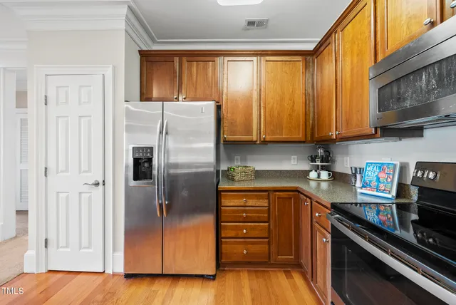 a kitchen with stainless steel appliances granite countertop a refrigerator and a stove