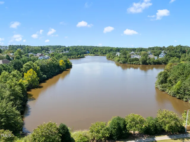 a view of a brick house with a yard and large trees