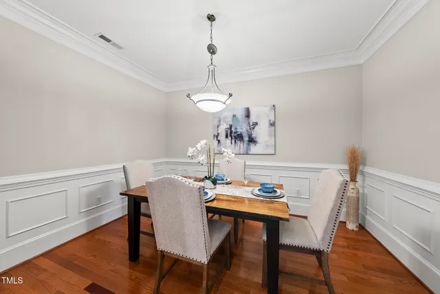 a view of a dining room with furniture a chandelier and wooden floor