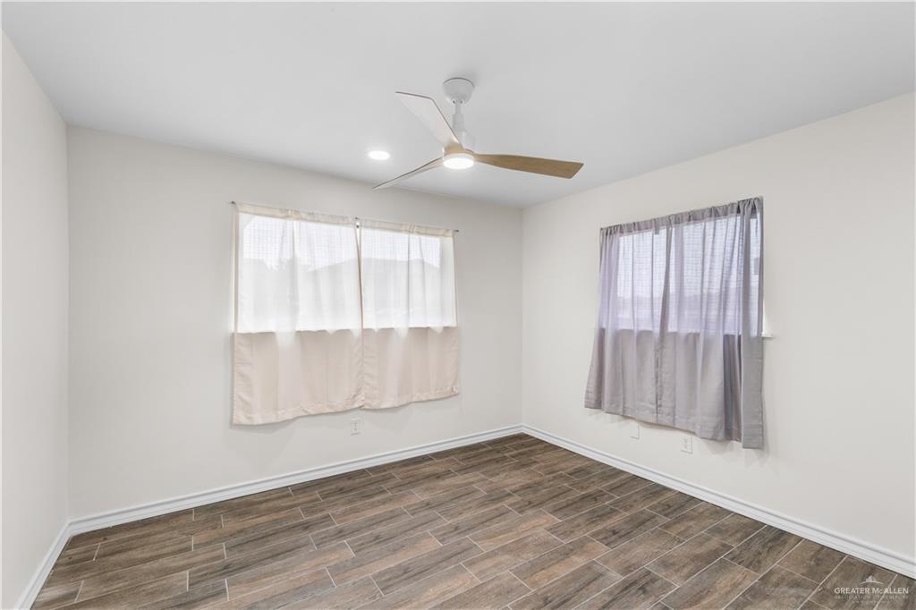 211 Gastel Circle, Unit 2 Edinburg, TX 78539 - Photo 14 of 22 an empty room with wooden floor and windows