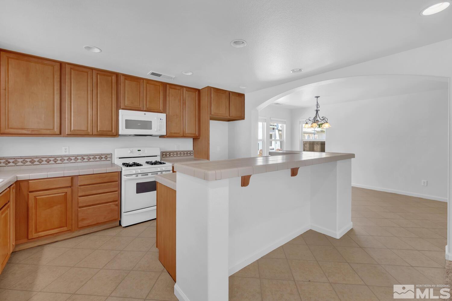 7696 Stone Bluff Way Reno, NV 89523 - Photo 11 of 40 a kitchen with stainless steel appliances granite countertop a stove and a sink