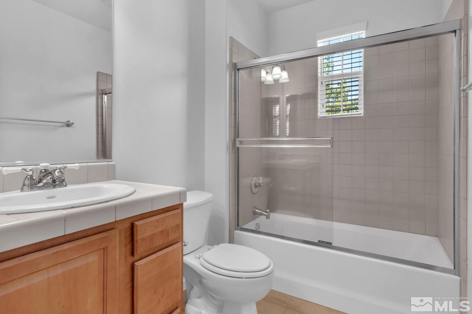 7696 Stone Bluff Way Reno, NV 89523 - Photo 28 of 40 a bathroom with a granite countertop sink a toilet and shower