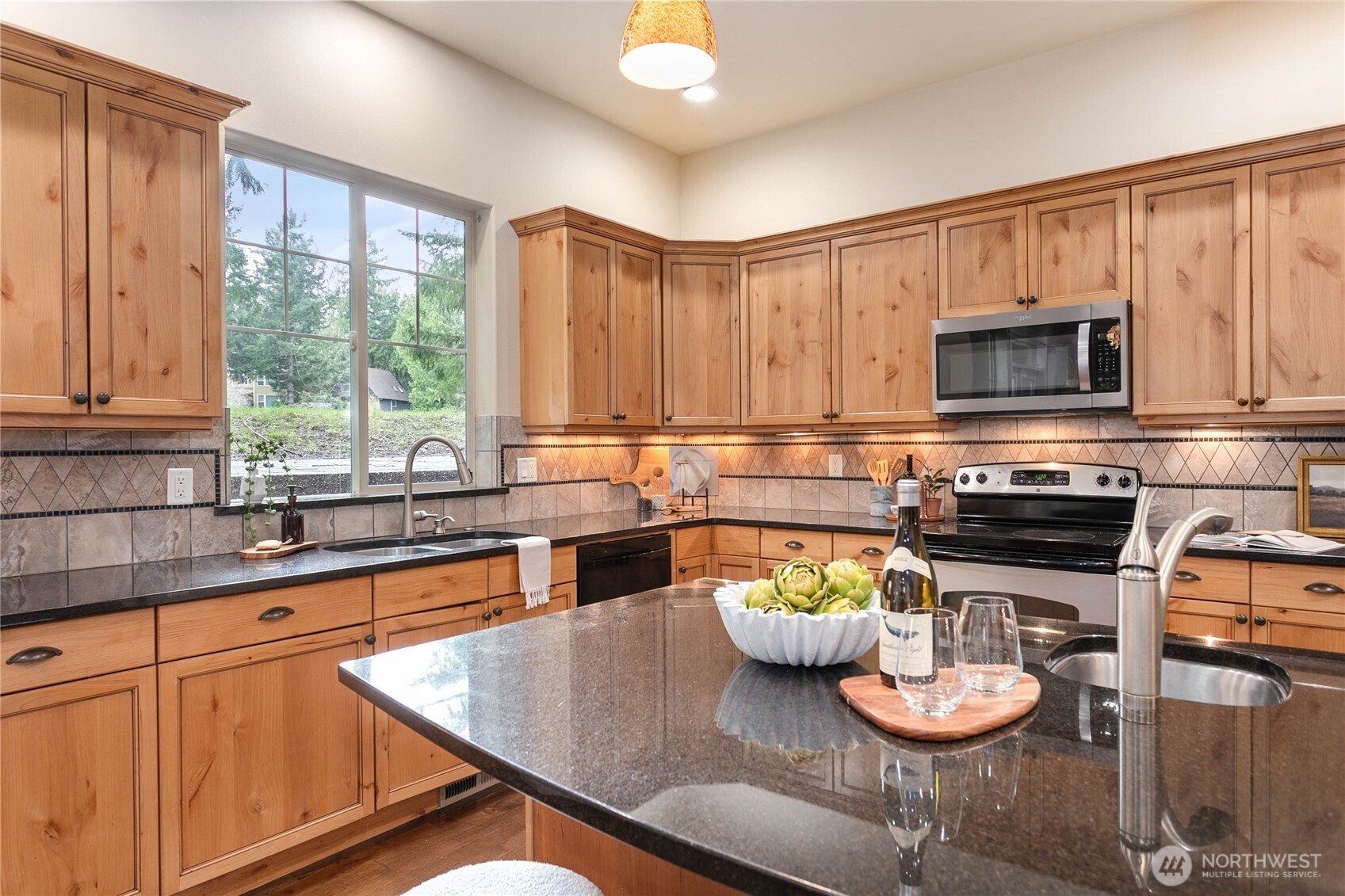 61 Windward Drive Bellingham, WA 98229 - Photo 11 of 36 a kitchen with a stove a microwave a dining table and chairs