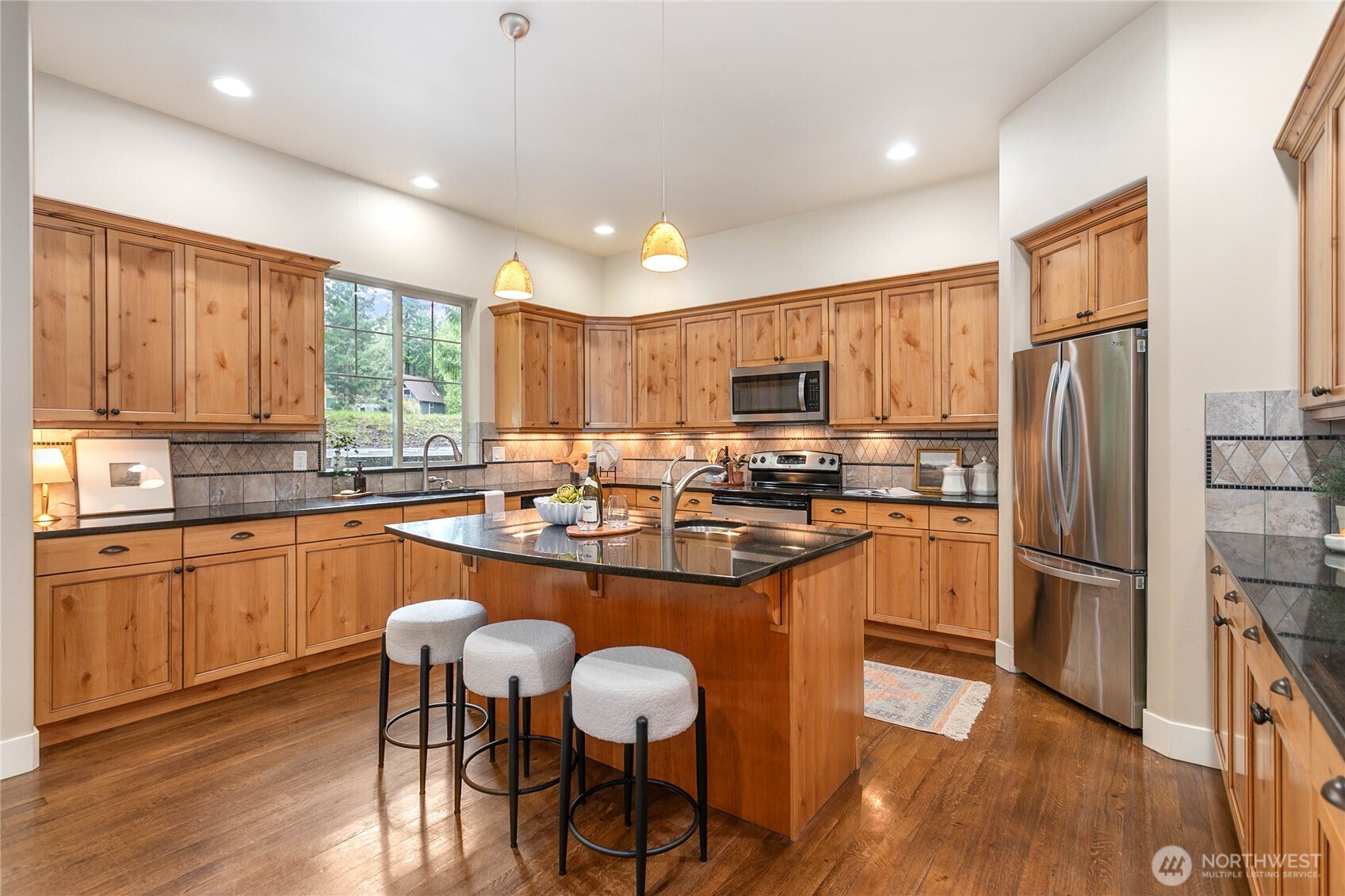 61 Windward Drive Bellingham, WA 98229 - Photo 9 of 36 a kitchen with stainless steel appliances granite countertop a refrigerator a stove top oven a sink dishwasher and wooden cabinets with wooden floor