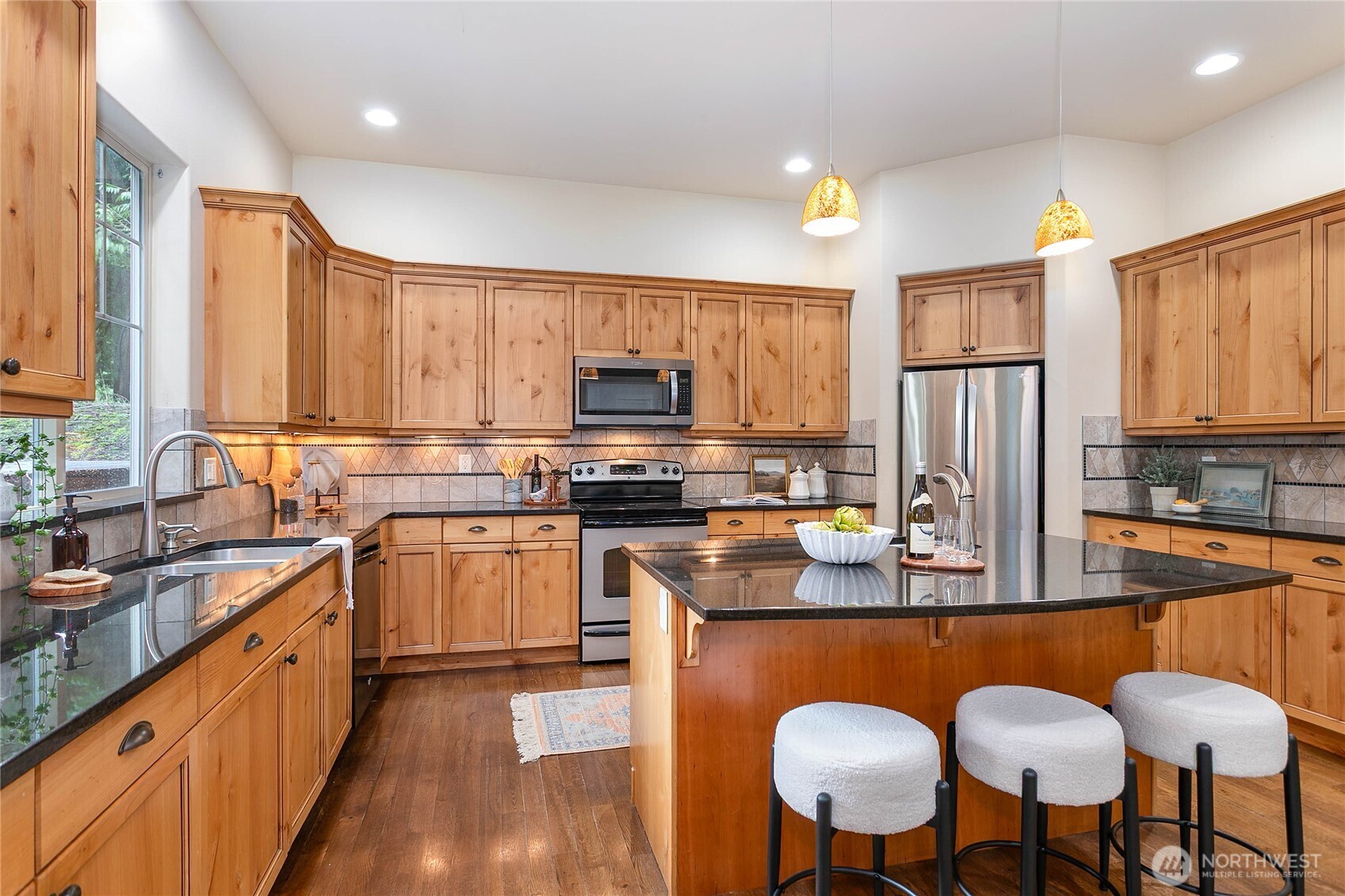 61 Windward Drive Bellingham, WA 98229 - Photo 10 of 36 a kitchen with stainless steel appliances granite countertop a stove a sink dishwasher a refrigerator with a dining table and chairs