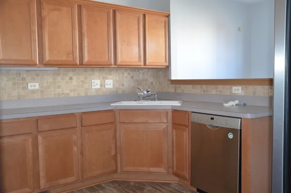 a kitchen with stainless steel appliances granite countertop white cabinets and a refrigerator