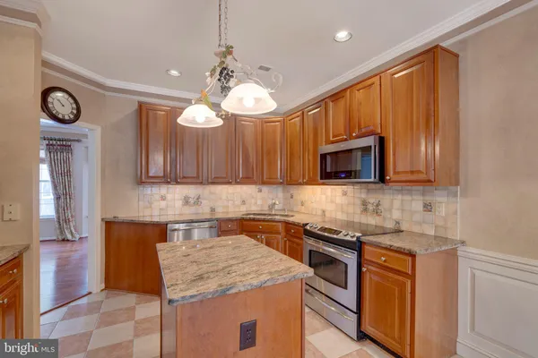 a kitchen with stainless steel appliances granite countertop wooden cabinets a stove top oven a sink and dishwasher