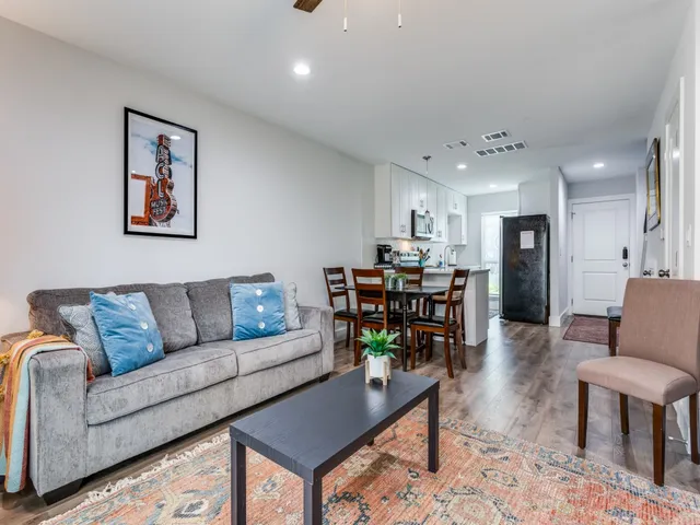 a living room with furniture and kitchen view