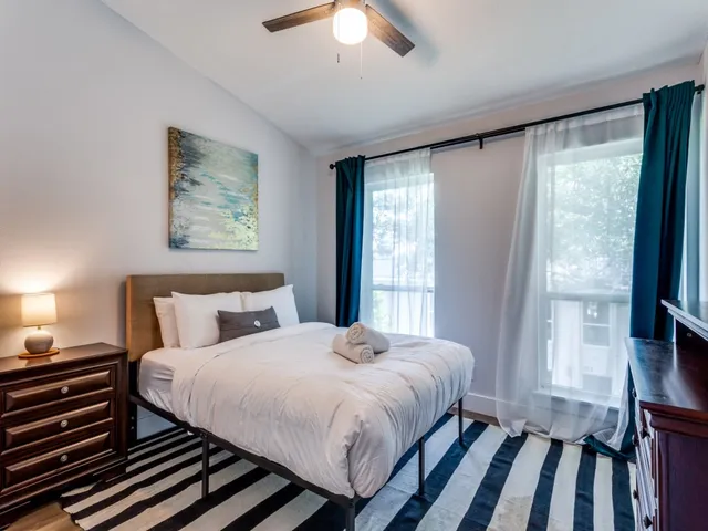 a bedroom with a bed and a large window