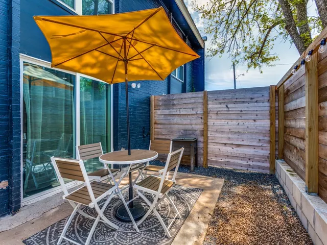 a patio with a table and chairs under an umbrella