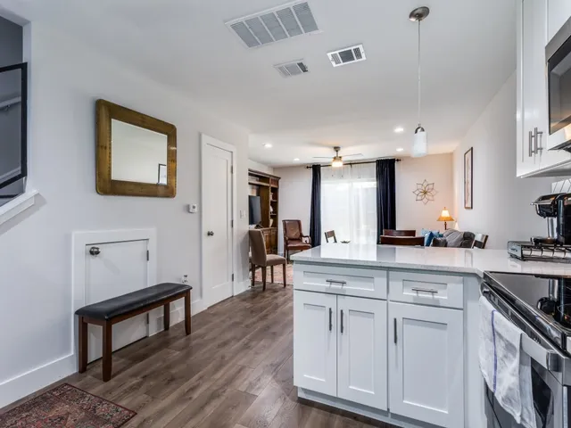 a kitchen with white cabinets and sink