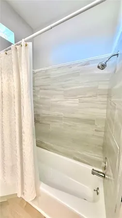a bathroom with a shower and a bath tub