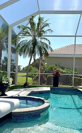 a view of a backyard with a patio and swimming pool
