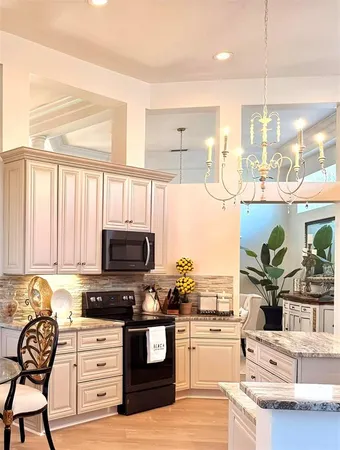 a kitchen with stainless steel appliances kitchen island granite countertop a stove a sink and a microwave
