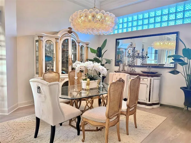 a dining room with furniture a large window and wooden floor