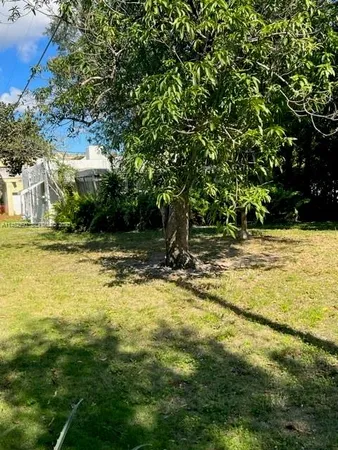 a view of swimming pool with lawn chairs and plants