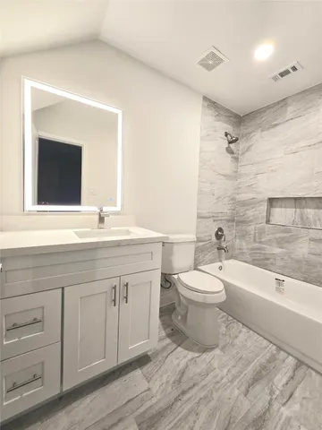 a bathroom with a toilet a sink a mirror and bathtub