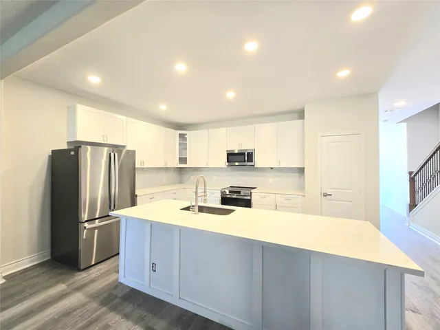 a kitchen with stainless steel appliances a refrigerator sink and microwave