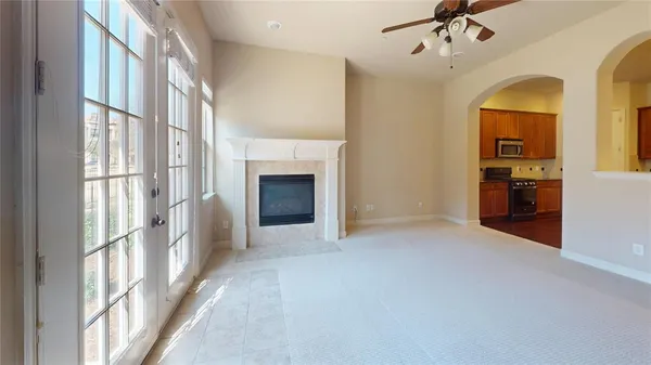 a view of an empty room with a fireplace and a window