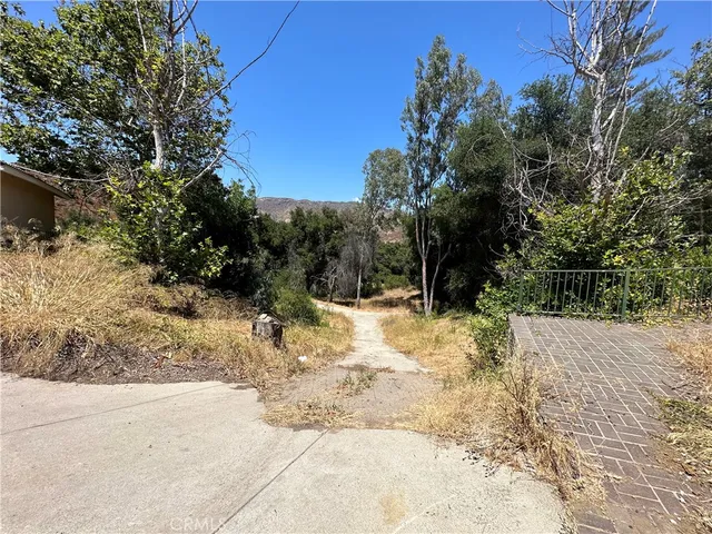a view of a yard with wooden fence