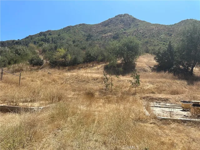 a view of a yard with wooden fence