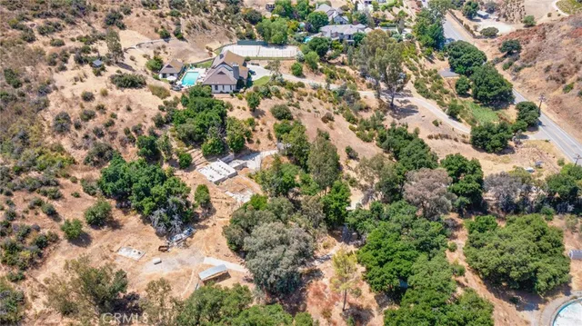 an aerial view of residential houses with outdoor space and trees