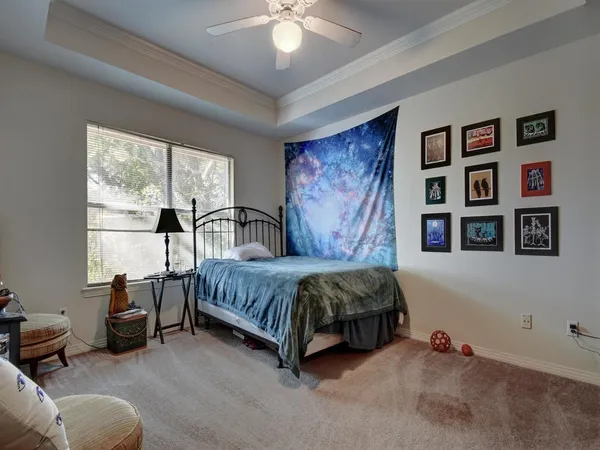 a spacious bedroom with a bed a couch and a large window