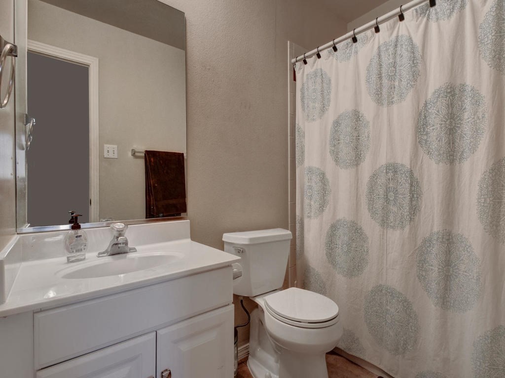 609 East 49th Street, Unit B Austin, TX 78751 - Photo 15 of 19 a bathroom with a sink a toilet and a mirror