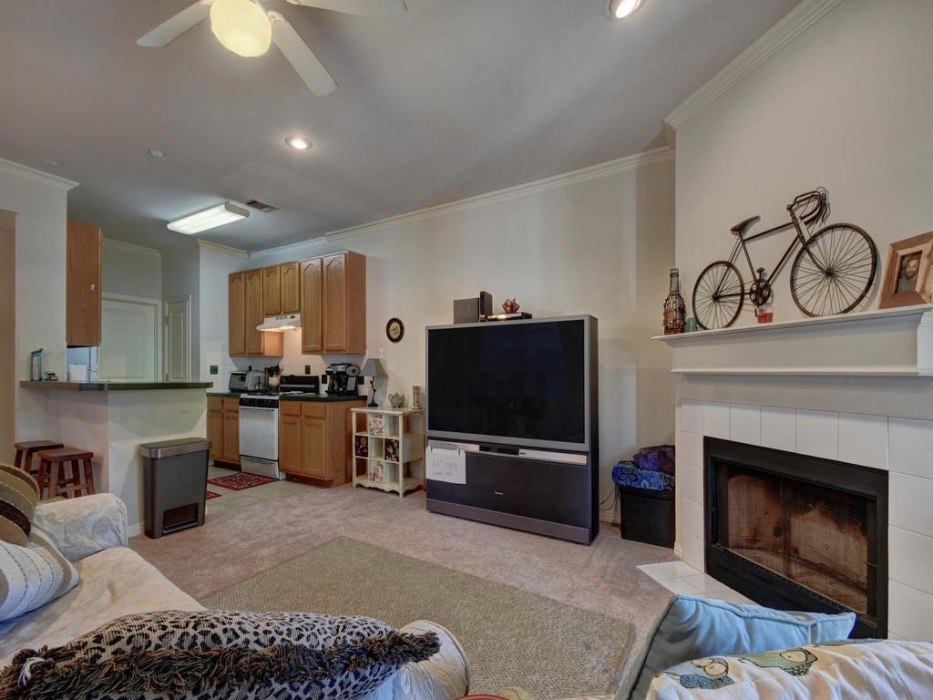 609 East 49th Street, Unit B Austin, TX 78751 - Photo 3 of 19 a living room with furniture a fireplace and a flat screen tv
