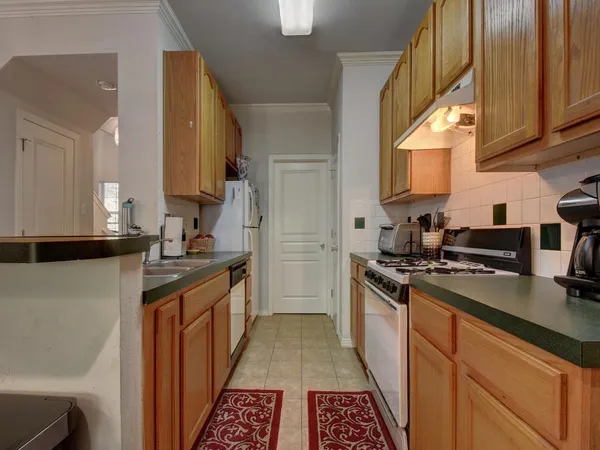 a kitchen with stainless steel appliances granite countertop a stove a sink dishwasher and a refrigerator