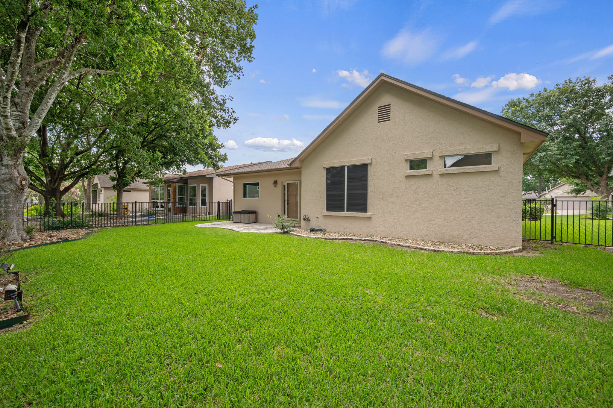 118 Bass Street Georgetown, TX 78633 - Photo 35 of 40 A vibrant green lawn and inviting patio area provide ample space for outdoor enjoyment.