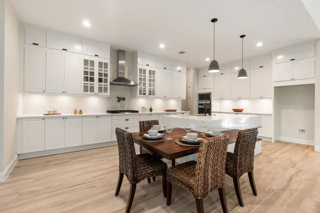 a kitchen with kitchen island granite countertop wooden floor cabinets and chairs