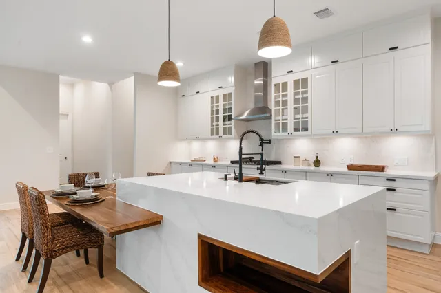 a kitchen with a sink a stove and wooden floor