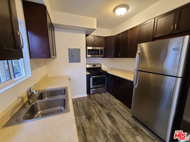 a kitchen with granite countertop a refrigerator and a sink