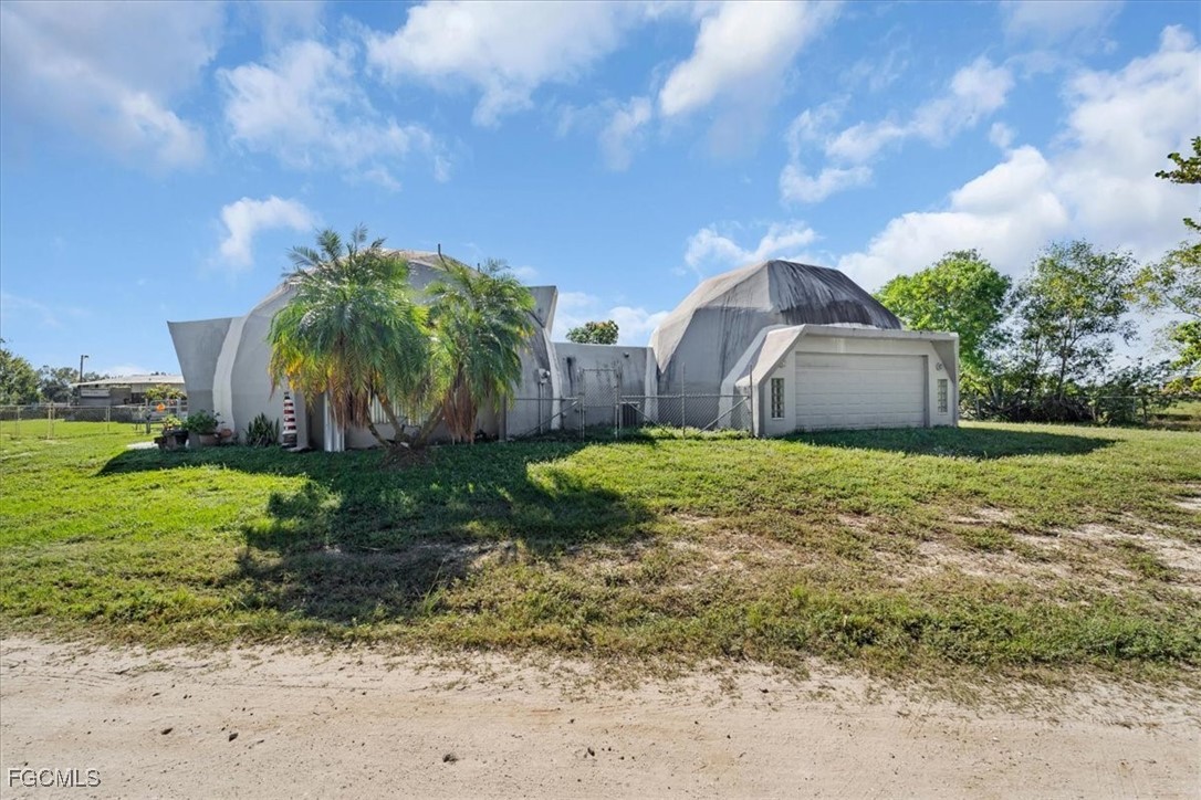 15871 Huffmaster Road North Fort Myers, FL 33917 - Photo 5 of 5 a backyard of a house with plants and large tree