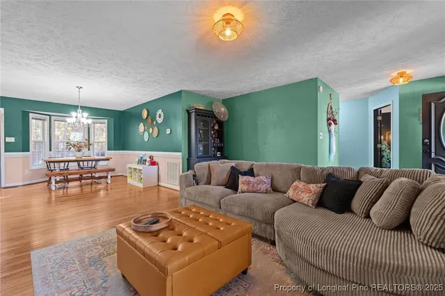 a kitchen with a refrigerator a sink dishwasher and a fireplace with wooden floor
