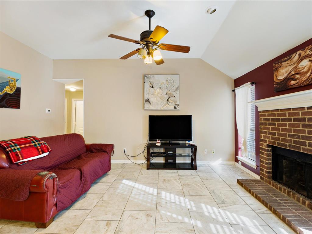 207 Quail Run Aubrey, TX 76227 - Photo 19 of 30 Living area featuring a ceiling fan, lofted ceiling, and a brick fireplace