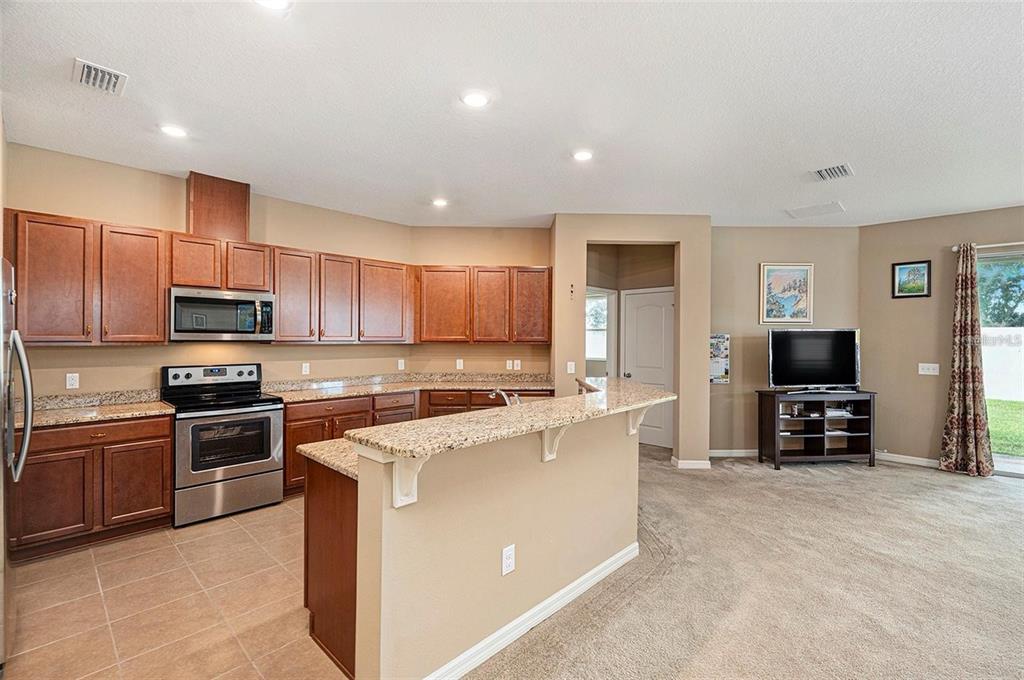 12343 Moss Lake Loop New Port Richey, FL 34655 - Photo 13 of 24 a kitchen with cabinets stainless steel appliances and a counter space