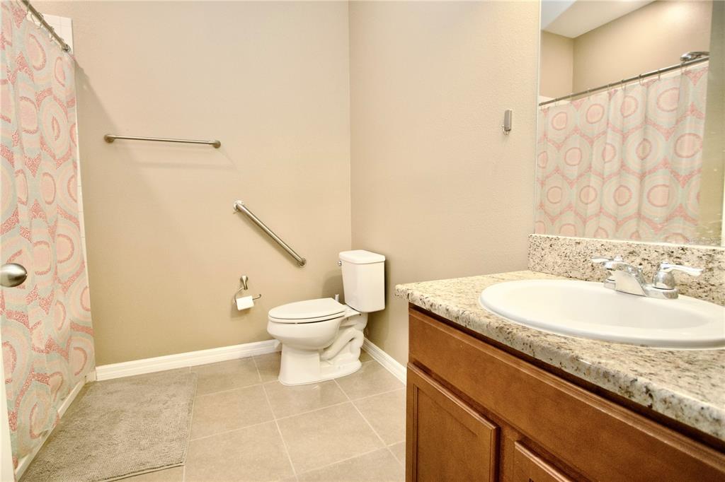 12343 Moss Lake Loop New Port Richey, FL 34655 - Photo 19 of 24 a bathroom with a granite countertop sink toilet and a shower