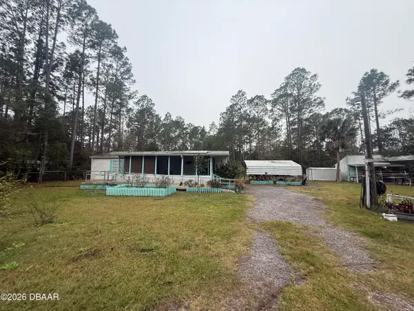 a view of a house with backyard sitting area and garden